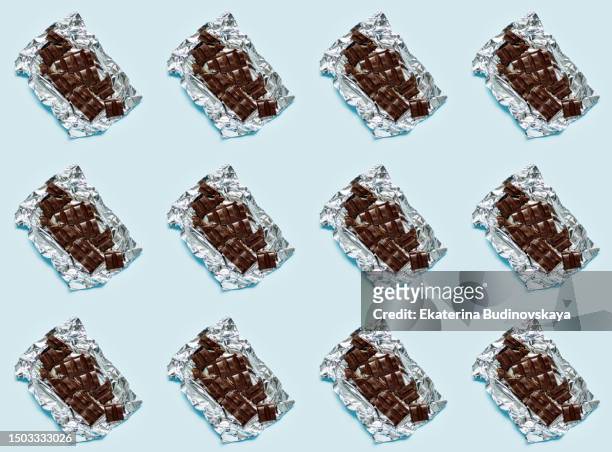 broken chocolate bar on colored background pattern - open chocolate bar stock pictures, royalty-free photos & images