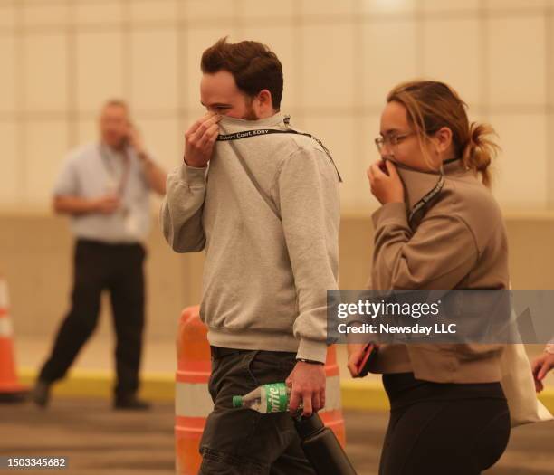 People cover their nose as they walk in Central Islip, New York on June. 7 due to smoky conditions caused by wildfires in Canada.