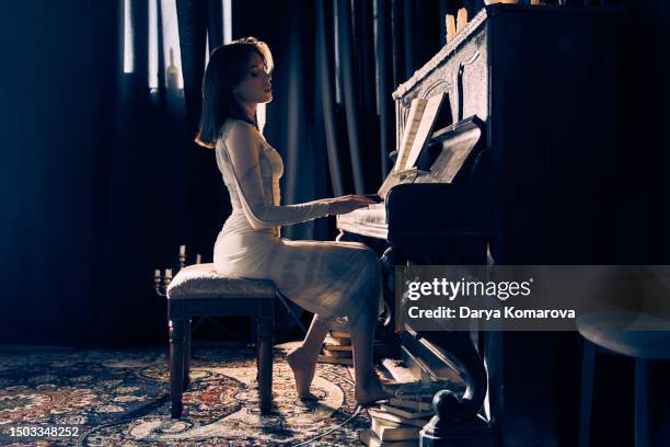 woman playing the piano. the concept of favourite hobby, learning how to play music on keyboard instruments, the poster with copy space. - same person different looks stock pictures, royalty-free photos & images