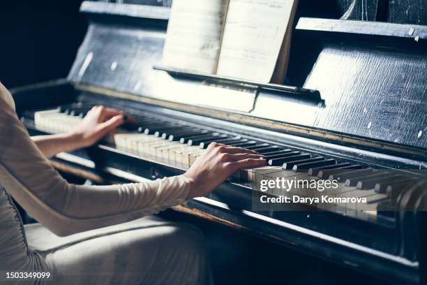 woman playing the piano. the concept of favourite hobby, learning how to play music on keyboard instruments, close up poster with copy space. - pianist stockfoto's en -beelden