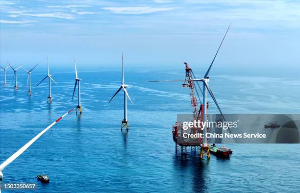 Workers install the world's first 16-megawatt offshore wind turbine at an offshore wind farm operated by China Three Gorges Corporation on June 28,...