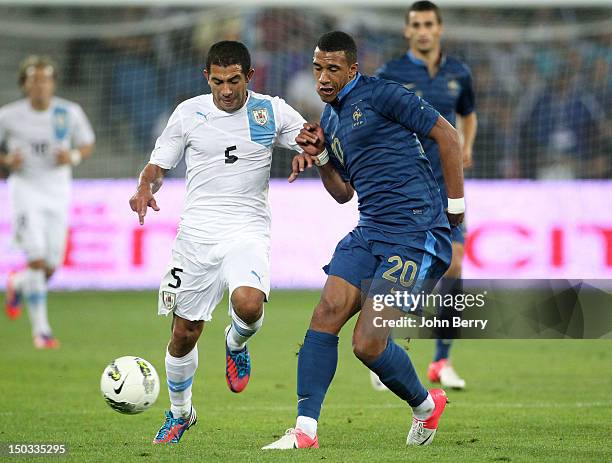 Etienne Capoue of France dribbles Walter Gargano of Uruguay during the international friendly match between France and Uruguay at the Stade Oceane on...