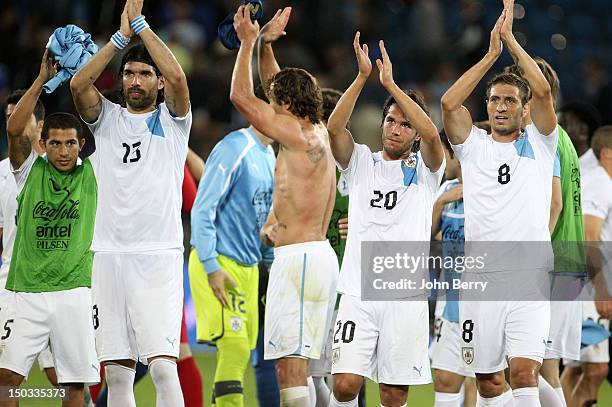 Walter Gargano, Sebastian Abreu, Diego Lugano, Alvaro Gonzalez and Sebastian Eguren of Uruguay salute the few uruguayan supporters after the...