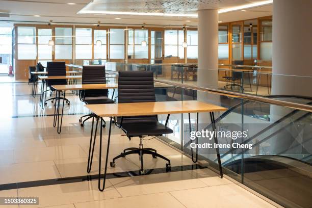 spacious open-plan interior of a co-sharing office - empty desk stock pictures, royalty-free photos & images