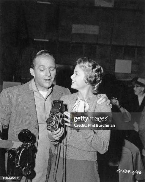 American singer and actor Bing Crosby with American actress Grace Kelly , circa 1955. Kelly is holding a Rolleiflex twin-lens reflex camera.