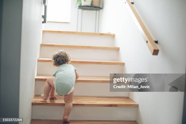 little cute toddler girl climbing on stairs at home - climbing stock pictures, royalty-free photos & images