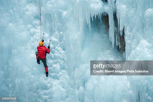 caucasian man climbing ice wall - ice pick stockfoto's en -beelden