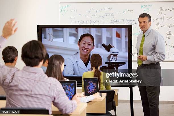 people watching instructor on monitor - school fair stock pictures, royalty-free photos & images