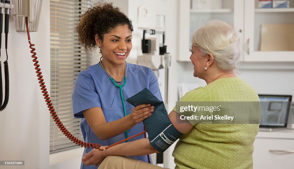 Nurse taking woman's blood pressure