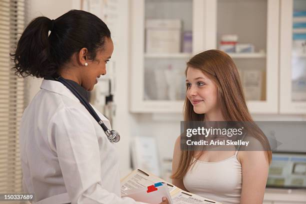 doctor hablando con el paciente en la sala de examen - teen and doctor fotografías e imágenes de stock