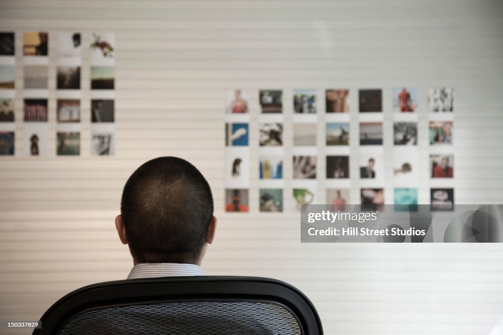 Pacific Islander Geschäftsmann auf der Suche auf Bilder an der Wand