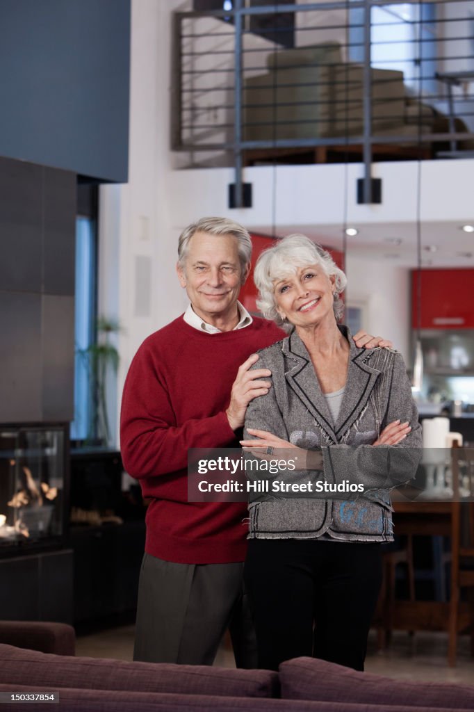 Smiling Caucasian couple standing together in living room