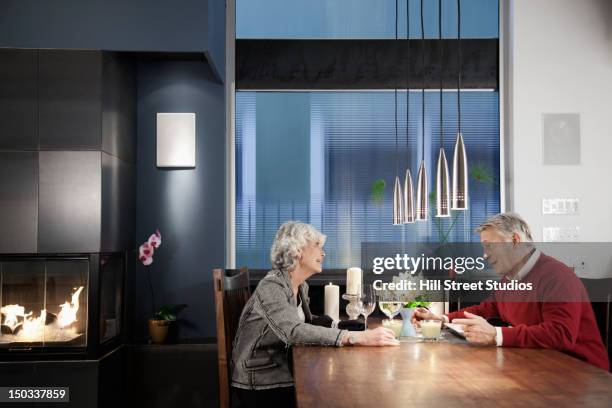 caucasian couple sitting at elegant dining room table - drinking alcohol at home stock pictures, royalty-free photos & images