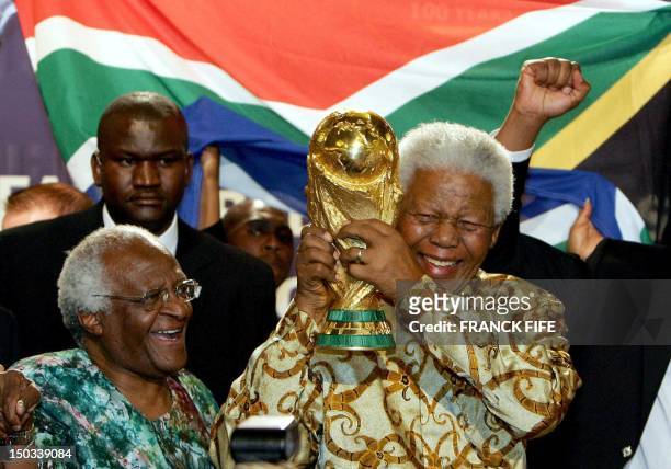 South African former President Nelson Mandela holds the Jules Rimet World cup beside Capetown Archbishop Desmond Tutu, 15 May 2004 at the FIFA...