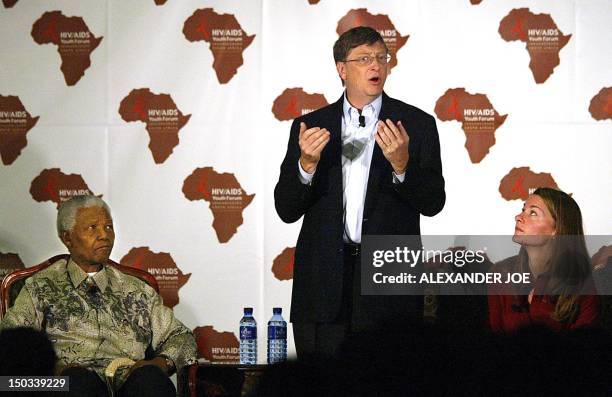 Microsoft owner Bill Gates addresses a youth forum on HIV/AIDS at the University of Witwatersrand in Johannesburg, 22 September 2003, as his wife...
