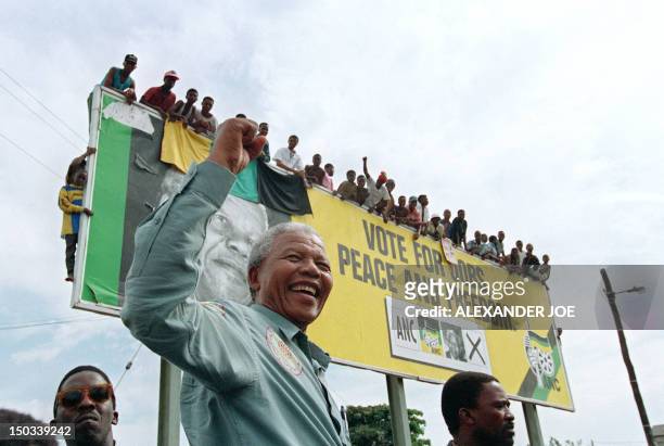 African National Congress President Nelson Mandela greets young supporters atop a billboard in a township outside Durban, 16 April 1994 prior to an...