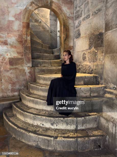 una mujer está sentada en las escaleras de la iglesia del santo sepulcro en la ciudad vieja de jerusalén - church of the holy sepulchre fotografías e imágenes de stock