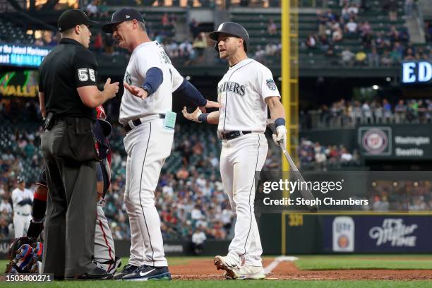 Manager Scott Servais of the Seattle Mariners talks with umpire Brennan Miller after he called a strike against Jarred Kelenic of the Seattle...