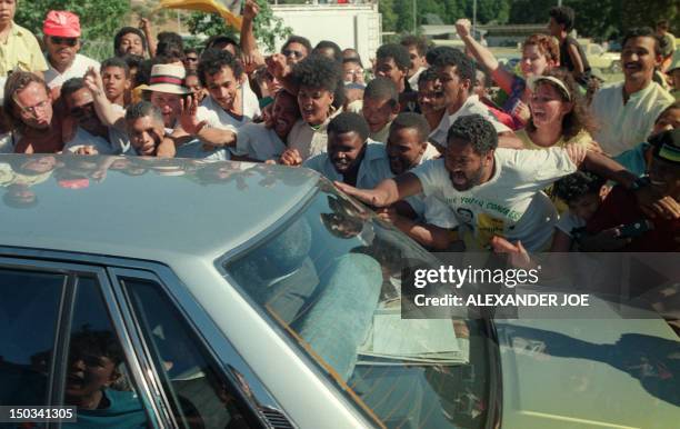 Anti-apartheid leader and African National Congress member Nelson Mandela rides in car through cheering fans as exiting from Victor Verster prison...