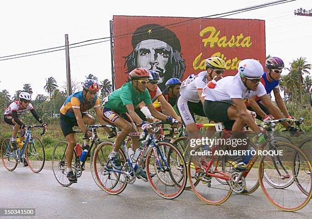 Riders in the tenth leg of the 9th Cyclists Tour of Cuba ride past a sign of Che Guevara before the last stretch of the race in Cardenas, Matanzas,...