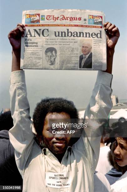 Young man holds a local newspaper announcing that ANC is unbanned, on February 02, 1990 in Cape Town during a demonstration of anti-Apartheid...