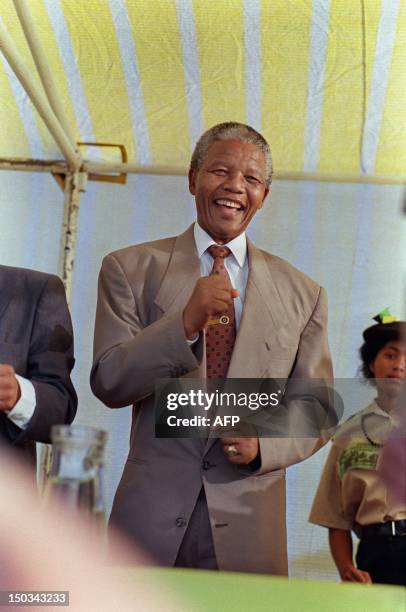 President Nelson Mandela laughs at a rally, 20 March 1992, in the west coast town of Saldhana, where he addressed the crowd, saying that all races...