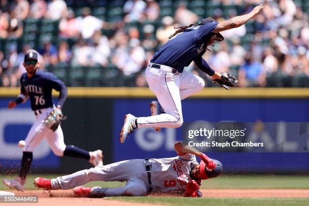 Jeimer Candelario of the Washington Nationals slides safely under J.P. Crawford of the Seattle Mariners as he steals second base during the third...