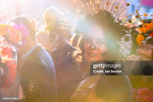 Young Mexican woman, dressed as La Catrina, a Mexican pop culture character representing the Death, takes part in the Day of the Dead celebrations on...