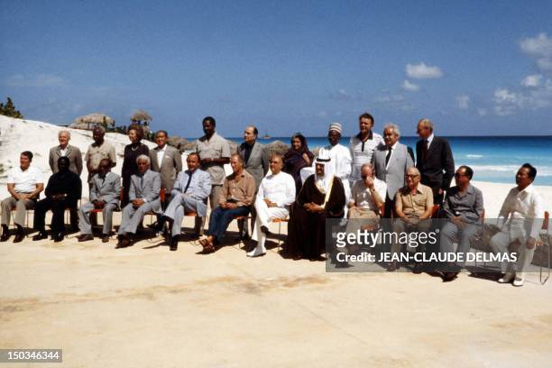 King Fahd ibn Abd al-Aziz of Saudi Arabia is surrounded 23 October 1981 in Cancun by 22 world leaders gathered for a family picture during the...