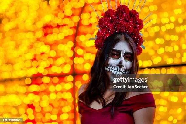 Young Mexican woman, dressed as La Catrina, a Mexican pop culture character representing the Death, takes part in the Day of the Dead celebrations on...