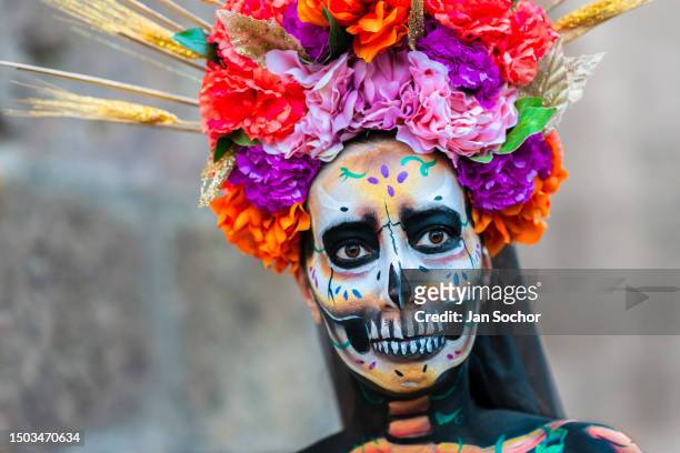 Young Mexican woman, dressed as La Catrina and wearing an elaborate flower headdress, takes part in the Day of the Dead festivities on November 1,...