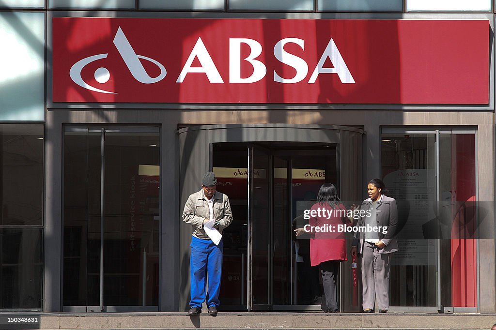 Customers are seen at the entrance to a bank branch at the... News ...
