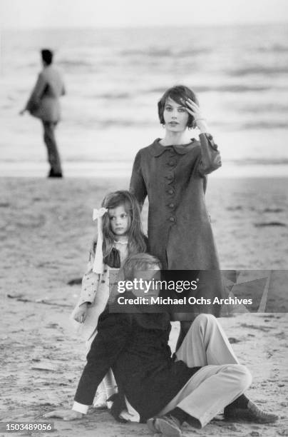 Actors Klaus Kinski and Ruth Brigitte Tocki with their daughter Nastassja Kinski pose for a portrait on the beach in Ostia in March 1966 in Rome,...
