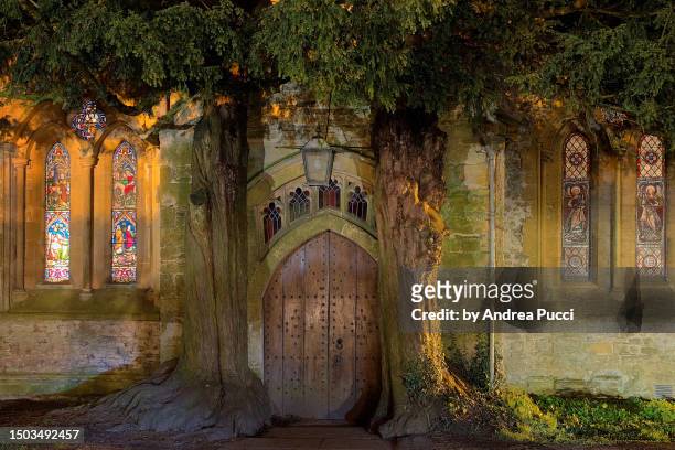 ancient yew trees at the north porch of to st edward's church, stow-on-the-wold, gloucestershire, united kingdom - yew stock pictures, royalty-free photos & images