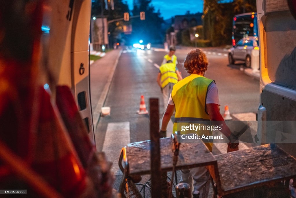 Road Maintenance Workers Preparing For Spray Painting The Road
