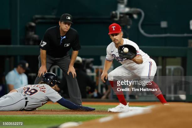 Zach McKinstry of the Detroit Tigers dives back to first base as Nathaniel Lowe of the Texas Rangers catches the ball in the first inning at Globe...
