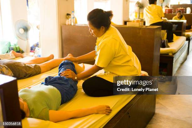 thai masseuse at work, wat po, ko ratanakosin. - ko ratanakosin stock pictures, royalty-free photos & images