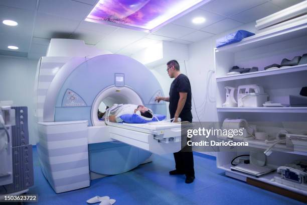 mann unterzieht sich einer mrt-untersuchung in einem krankenhaus - mri stock-fotos und bilder