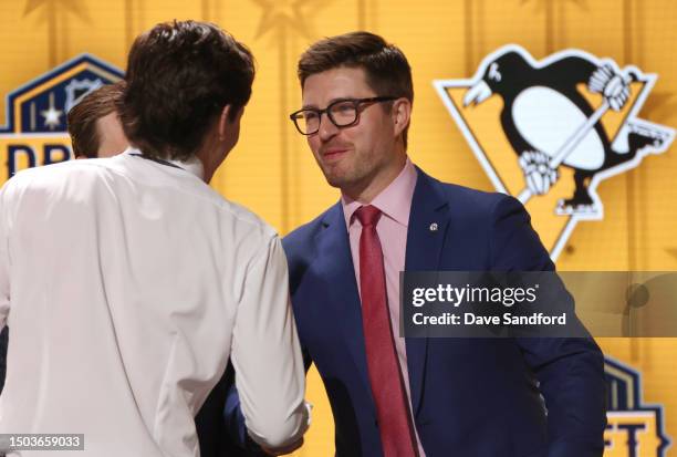 Brayden Yager shakes the hand of president of hockey operations Kyle Dubas onstage after being selected 14th overall by the Pittsburgh Penguins...