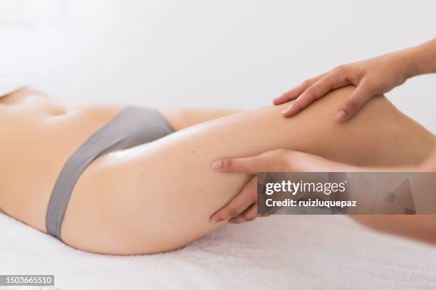 massaggiatore che massaggia le gambe di una donna in un centro termale - fisioterapia foto e immagini stock