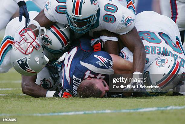 Running back Marc Edwards of the New England Patriots helmet pops off as he is tackled during the game against the Miami Dolphins on October 6, 2002...