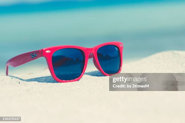 red sunglasses on a sunny beach - red sunglasses stock pictures, royalty-free photos & images