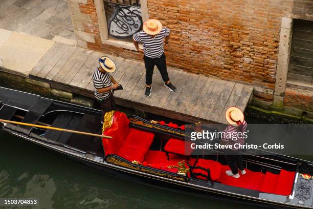 Three Gondoliers and a Gondola on the canal's of Venice, on August 17 in Venice, Italy.