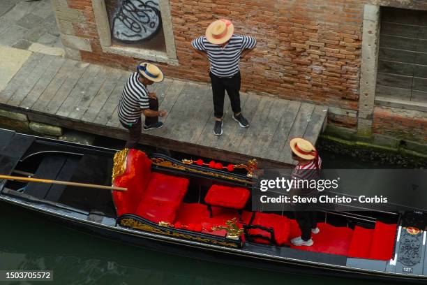 Three Gondoliers and a Gondola on the canal's of Venice, on August 17 in Venice, Italy.