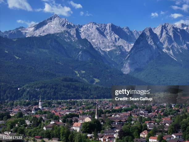 In this aerial view the town center stands below a mountain range that includes Alpspitze peak on June 26, 2023 in Garmisch-Partenkirchen, Germany....