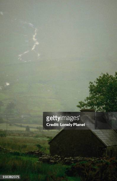 mountain valley and farm building on a misty day, gap of dunloe, killarney, county kerry - lpiowned stock pictures, royalty-free photos & images