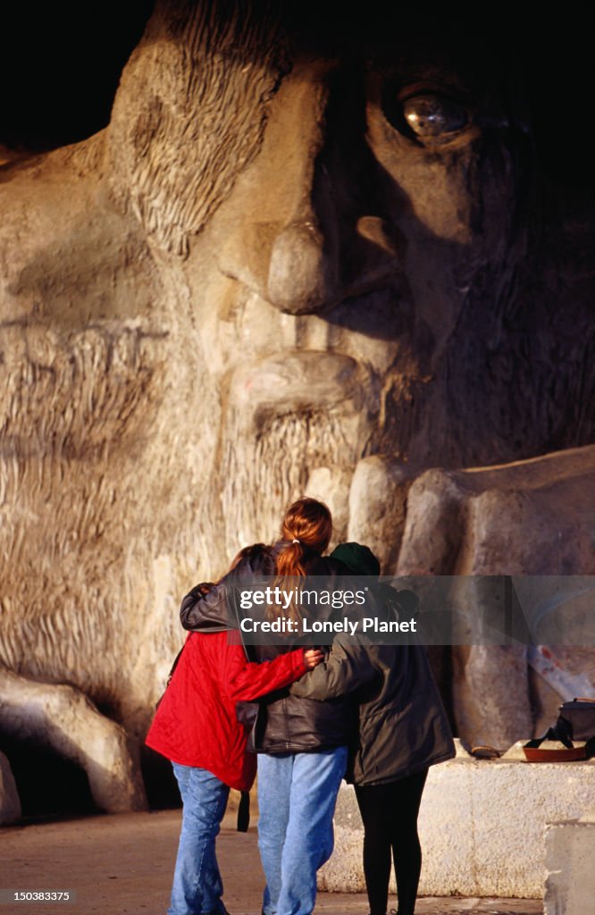 Tourists pose for photos at the Fremont Troll statue, 18 feet high.