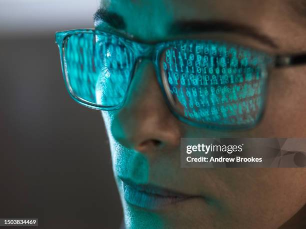 close-up of programmer with binary code reflected in eyeglasses - binary code stock pictures, royalty-free photos & images