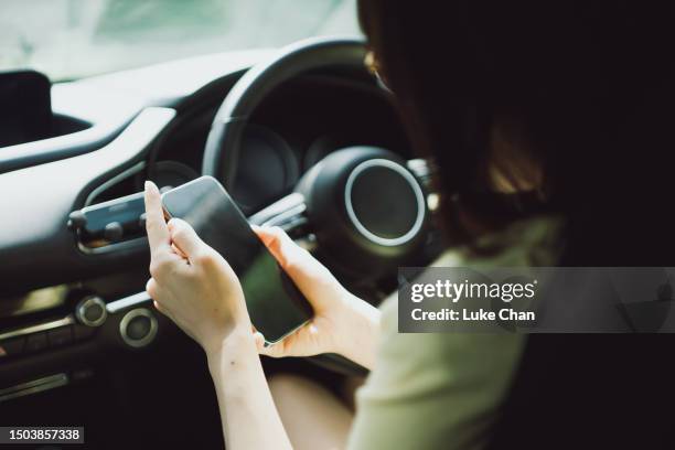 asian woman using smartphone in a car - front passenger seat stock pictures, royalty-free photos & images