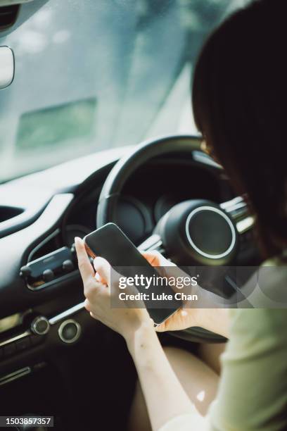 asian woman using smartphone in a car - front passenger seat stock pictures, royalty-free photos & images